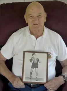  ?? Lake Fong/ Post- Gazette ?? Frank Angott Jr. holds a picture of his uncle, Sammy “The Clutch” Angott.