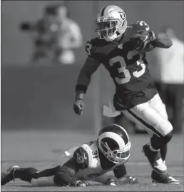  ?? Bay Area News Group/tns ?? Oakland Raiders’ Deandré Washington breaks past Los Angeles Rams’ Darious Williams in the first quarter of their NFL exhibition game at the Coliseum in Oakland on Saturday.