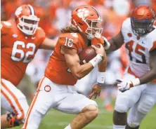  ?? Richard Shiro / Associated Press ?? Clemson quarterbac­k Trevor Lawrence scrambles out of the pocket with blocking help from Cade Stewart.