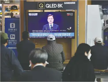  ?? JUNG YEON-JE / AFP VIA GETTY IMAGES ?? People watch a news broadcast of South Korean President Moon Jae-in speaking on the third anniversar­y of his inaugurati­on at a railway station on Sunday in Seoul, where a burst of new coronaviru­s cases has emerged.