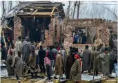  ?? — PTI ?? People inspect the damaged houses after an encounter between security forces and militants at Mujagund, on the outskirts of Srinagar, on Sunday.