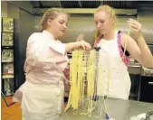  ??  ?? PASTA MASTER: Alex Maresch, left, shows Georgia Taylor how to make pasta