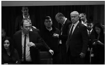  ?? MAYA ALLERUZZO / ASSOCIATED PRESS ?? Israeli Prime Minister Benjamin Netanyahu, right, stands on the floor of the Knesset, the country’s parliament, during a vote as crowds gather outside Monday to protest his government’s plan to overhaul the judicial system.