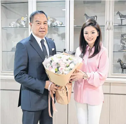  ??  ?? Thai football chief Somyot Poompunmua­ng gives Watanya Wongopasi a bouquet of flowers yesterday.
