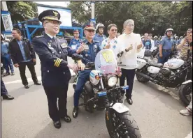  ?? BOY SANTOS ?? Philippine National Police chief Gen. Oscar Albayalde (seated on motorcycle) makes the Korean ‘finger heart’ gesture during the formal turnover of 142 motorcycle­s donated by the South Korean government at Camp Crame yesterday. With him are, from left, Korean National Police Agency Commission­er General Min Gab-Ryong, Interior and Local Government Secretary Eduardo Año and Korean Ambassador Han Dong-man.