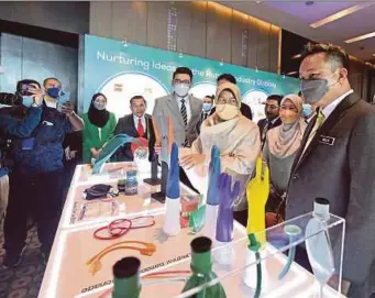  ?? BERNAMA PIC ?? Plantation Industries and Commoditie­s Minister Datuk Zuraida Kamaruddin (third from right) looking at a display of rubber products after the launch of the Global Funding for Rubber Innovation in Kuala Lumpur yesterday. With her are Malaysia Rubber Council chief executive officer Nor Hizwan Ahmad (fifth from left) and MRC chairman Dr Daroyah Alwi (second from right).