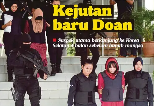  ??  ?? SITI Aisyah (belakang) dan Doan (depan) dikawal anggota polis ketika keluar dari Mahkamah Tinggi Shah Alam, semalam.