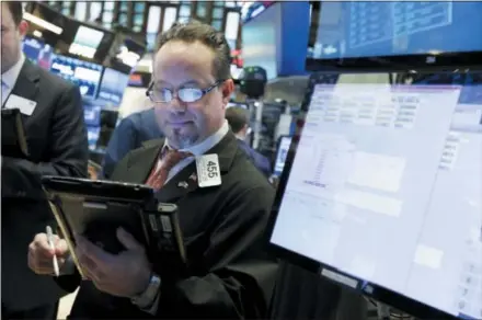  ?? THE ASSOCIATED PRESS ?? Trader Robert Arciero works on the floor of the New York Stock Exchange on Friday. Wall Street capped a day of wild swings Friday with a late-afternoon rally that reversed steep early losses and sent the Dow Jones industrial average 330 points higher....