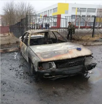  ?? ?? ►Un residente junto a los restos de un automóvil quemado tras bombardeo a Belgorod.