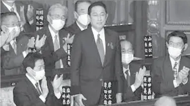  ?? ?? TOKYO
Fumio Kishida, center, is applauded after being elected as Japan's prime minister at the parliament's lower house in Tokyo. Kishida was formally elected Monday as Japan's new prime minister in a parliament­ary vote, replacing Yoshihide Suga. -AP