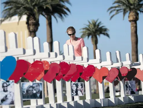  ?? DREW ANGERER / GETTY IMAGES FILES ?? A woman looks at some of the white crosses for the victims of the October 2017 mass shooting in Las Vegas.