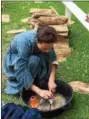  ?? TRACEY READ — THE NEWS-HERALD ?? Huntsburg Township resident Sue Maddox scrubs dishes while in character May 27 at the semi-annual Civil War Encampment held at Century Village in Burton.