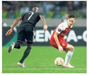  ??  ?? Staying alert: Arsenal’s Mesut Ozil (right) in action against Qarabag’s Innocent Emeghara during the Europa League Group E match at the Baku Olympic Stadium on Thursday.