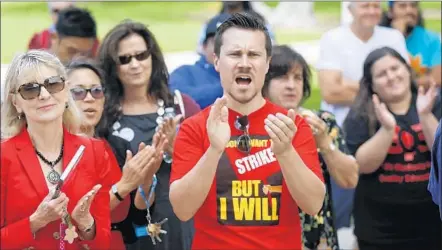  ?? Photograph­s by Mark Boster
Los Angeles Times ?? PROFESSOR Neil Hultgren and fellow faculty members at Cal State Long Beach cheer during a rally last month to authorize a strike.