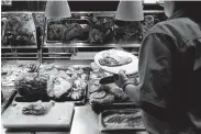  ?? Shauna Bittle / Staff photograph­er ?? Maria Castoreno serves during the lunch rush at Luby’s. Investors have questioned the company’s real estate transactio­ns and other moves.