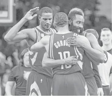  ?? Paul Battaglia / Associated Press ?? Rockets guard James Harden, right, and teammates Eric Gordon (10) and Trevor Ariza celebrate their overtime win over the Timberwolv­es. The three combined for 59 points and 10 of the team’s 3-point shots.