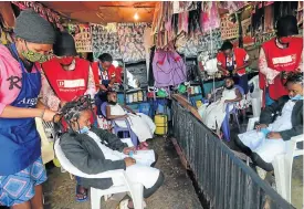  ?? Picture: Reuters/Thomas Mukoya ?? In Nairobi, Kenya, this week, Martha Apisa, left, and Stacy Ayuma get their hair plaited in the ‘coronaviru­s’ style as a fashion statement against the pandemic.