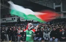  ?? Mustafa Majed ?? A fan waves the Palestinia­n flag amid cheering for the national team at the Gazan recreation centre