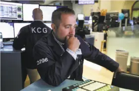  ?? Richard Drew / Associated Press ?? Gennaro Saporito works at his post on the floor of the New York Stock Exchange. More signs of weakness in China’s economy sent markets lower.