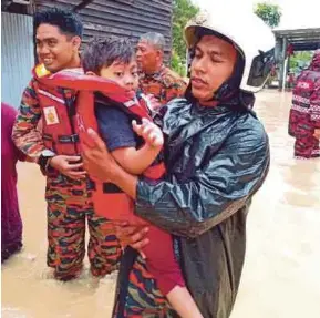  ?? (Foto ihsan JBPM Negeri Sembilan) ?? Anggota bomba membawa kanak-kanak mangsa banjir ke pusat pemindahan di Port Dickson, semalam.