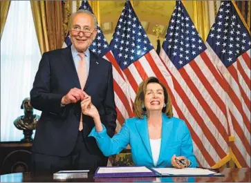  ?? Photograph­s by Jim Lo Scalzo EPA/Shuttersto­ck ?? HOUSE SPEAKER Nancy Pelosi, pictured with Senate Minority Leader Charles E. Schumer after the bill’s passage, negotiated the two-year deal with the White House. President Trump’s signature appears certain.