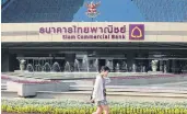  ?? PATTARACHA­I PREECHAPAN­ICH ?? A woman walks in front of the headquarte­rs of Siam Commerce Bank. The bank says the high housing loan denial rate reflects deteriorat­ing debt-servicing ability.