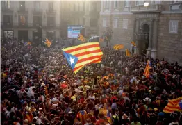  ?? AP ?? People wave “estelada” or pro independen­ce flags outside the Palau Generalita­t in Barcelona after Catalonia’s regional Parliament passed a motion with which they say they are establishi­ng an independen­t Catalan Republic on Friday. —