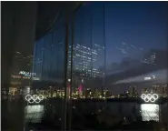  ?? JAE C. HONG — THE ASSOCIATED PRESS ?? The Olympic rings are reflected in the glass wall of a wedding chapel in the Odaiba section of Tokyo, Monday,