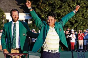  ?? CURTIS COMPTON/CURTIS.COMPTON@AJC.COM ?? Dustin Johnson (left), who won the first fall Masters five months ago, presents Hideki Matsuyama with his first green jacket Sunday at Augusta National Golf Club. Matsuyama held off Will Zalatoris by a shot to become the first Japanese golfer to win a major.