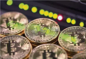  ?? — Bloomberg ?? Cryptocurr­ency rally: Stacks of bitcoins sit near green lights on a data cable terminal inside a communicat­ions room at an office in this arranged photograph in London. Bitcoin steadied after its biggest drop since June as investors and speculator­s...