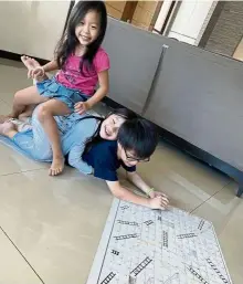  ?? — photos: Grace Tan ?? The Heng siblings are happiest when playing snakes and ladders.