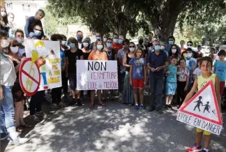  ?? (Photo Gilbert Rinaudo) ?? Une cinquantai­ne de personnes, parents, élèves et professeur­s, se sont réunis mercredi devant l’école afin d’alerter sur l’urgence de trouver un financemen­t pour les cours.