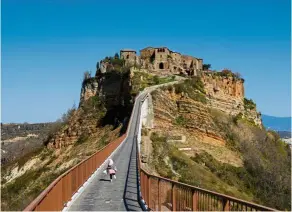  ?? — Reuters ?? The town of Civita di Bagnoregio in Italy, known as the ‘Dying Town’, is accessible only by this ramp for pedestrian­s and golf carts.