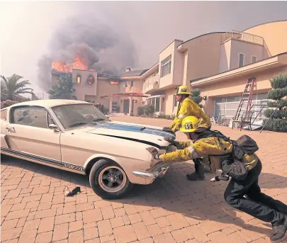  ?? Ringo chiu/ap ?? Los bomberos intentaban salvar un auto en una casa en llamas en Malibú