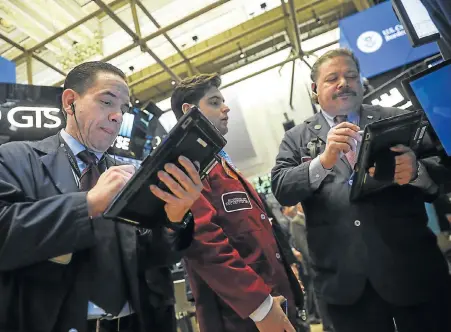  ?? Picture: DREW ANGERER/GETTY IMAGES/AFP ?? FUTURE UNCERTAIN: Traders work at the New York Stock Exchange. After a chaotic trading day on Wednesday, the Dow opened higher yesterday. Markets continue to be on edge due to concerns over a potential trade war between the US and China