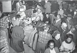  ?? Wayne F. Kelly Los Angeles Times ?? SHOPPERS flood a May Co. department store for a sale in 1958. In 1939, the architectu­rally striking May Co. building opened on Wilshire Boulevard.