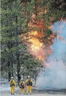  ?? TERRAY SYLVESTER GETTY IMAGES ?? California Fire firefighte­rs monitor flames above State Highway 299 while battling the Carr Fire on Monday west of Redding, California.