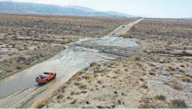  ?? JAY CALDERON/USA TODAY NETWORK ?? Vehicles stop on Dillon Road about a mile east of Thousand Palms Canyon Road in the Coachella Valley in California after heavy rain deposited mud and rocks there, making the road largely impassable.
