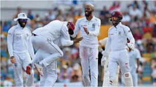  ?? AFP ?? Part-time West Indian spinner Roston Chase (Centre) took eight England wickets in the second innings of the first Test in Barbados. —