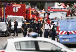  ?? — AFP ?? FATAL HOSTAGE DRAMA: French police officers and fire engine arrive at the scene of a hostage-taking at a church in Saint-Etienne-du-Rouvray, France, on Tuesday that left the priest dead.