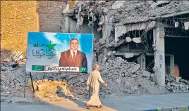  ?? ?? A campaign poster for parliament­ary elections is displayed near destroyed buildings from fighting between Iraqi forces and the Islamic State group in Mosul, Iraq.