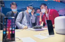  ?? MARK SCHIEFELBE­IN/AP 2020 ?? People look at smartphone­s and consumer electronic­s from Chinese technology firm Huawei Technologi­es Ltd. in October at the PT Expo in Beijing.