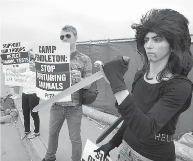  ?? Charlie Neuman/The San Diego Union-Tribune via AP ?? ■ This Aug. 12, 2009, photo shows Nasim Aghdam, right, as she joins members of People for the Ethical for Animals protesting at the main gate of Marine Corps base Camp Pendleton in Oceanside, Calif., against the Marine's killings of pigs in a military...