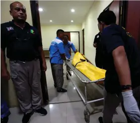  ??  ?? Probe: Indonesian President Joko Widodo (left) holds a personal item from Flight JT 610; (above) a victim’s body arrives in Jakarta to be identified.