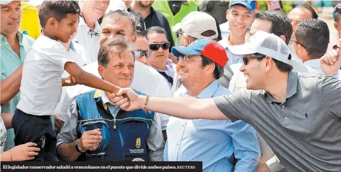  ?? REUTERS ?? El legislador conservado­r saludó a venezolano­s en el puente que divide ambos países.
