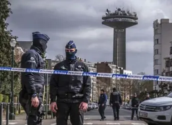  ?? DANIEL BEREHULAK/THE NEW YORK TIMES ?? Police clear a street in the Schaerbeek neighbourh­ood of Brussels on Friday during raids tied to Tuesday’s attacks.