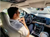  ??  ?? AT EASE: Safety driver of a driverless car enjoys the ride during a trip on a Dubai street.