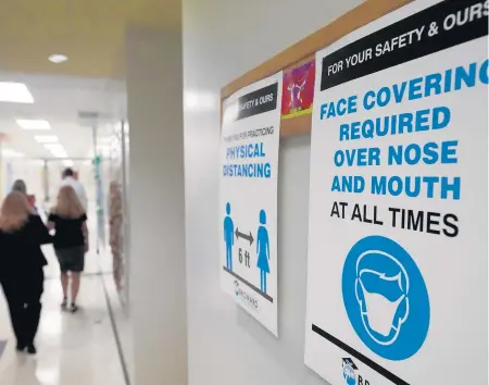  ?? WILFREDOLE­E/AP ?? Signs in a hallway Friday remind students towearmask­s and distance themselves at FoxTrail Elementary­School inDavie. Broward County schools began a phased reopening for face-to-face eLearning Friday.