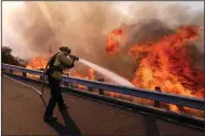  ?? (AP/Ringo H.W. Chiu) ?? A firefighte­r works along California 118 in Simi Valley in 2018, the deadliest year for wildfires in California history.