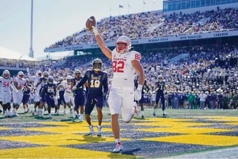  ?? Photos by Julio Cortez/Associated Press ?? Houston tight end Matt Byrnes celebrates after scoring a touchdown during the first half of Saturday’s game in Annapolis, Md.